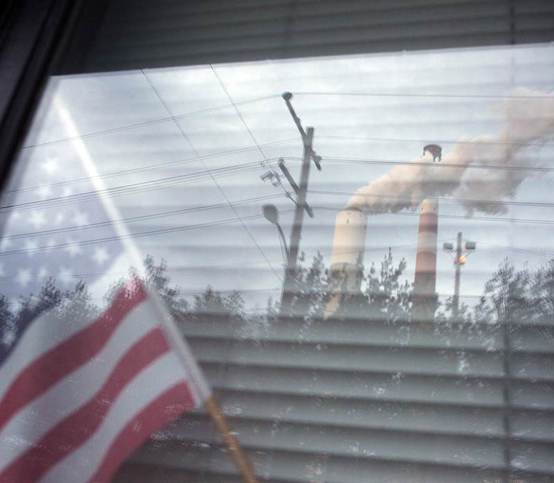A coal-fired power plant in Pennsylvania, reflected in a neighboring home&#039;s window.