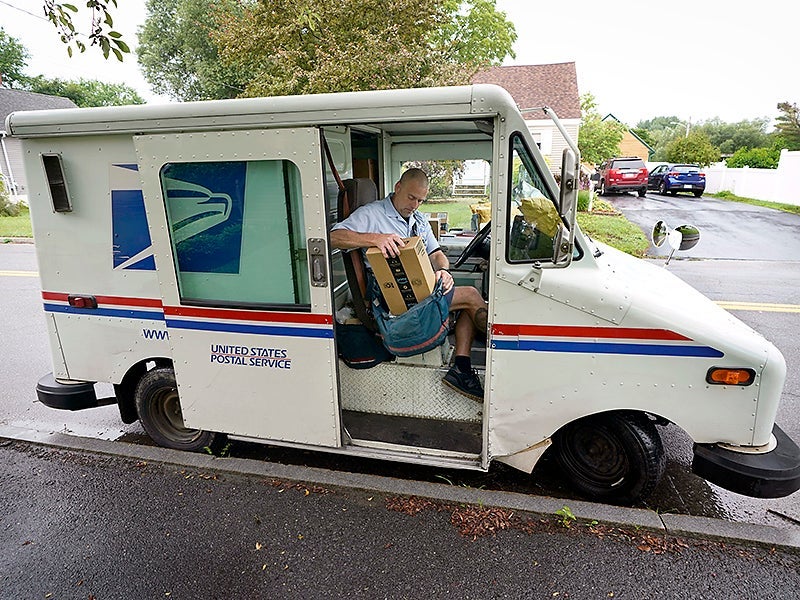 El cartero del USPS, John Graham, empaca su bolsa de correo después de estacionar un camión de reparto que cumple 28 años de servicio, el 14 de julio de 2021, en Portland, Maine.
