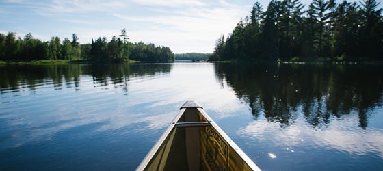 Canoeing over glassy water in the Boundary Waters Canoe Area Wilderness. (Brad Zweerink / Earthjustice)