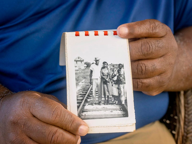 Ironton resident Wilkie DeClouet, the husband of Andrea, holds a family photograph.