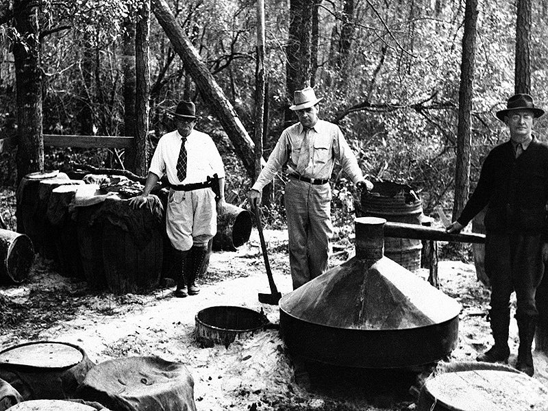 The aftermath of a raid by Federal Reserve officials on moonshiners in Florida on Nov. 24, 1950, where a small still with six barrels of mash was concealed in a forest.