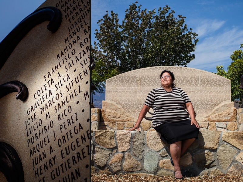 Graciela Silva worked for nine years in the fields harvesting lemons, lettuce, cucumbers, and strawberries. She sits in front of a monument, that includes her name, honoring local farmworkers in Santa Paula, CA.