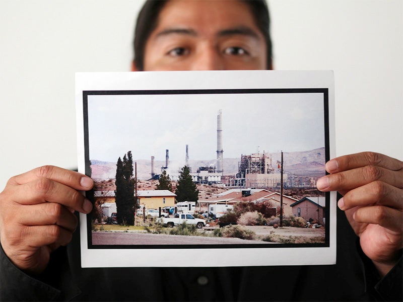 Moapa Band of Paiutes Tribal Chairman William Anderson holds a photo of the Reid Gardner Power Station.