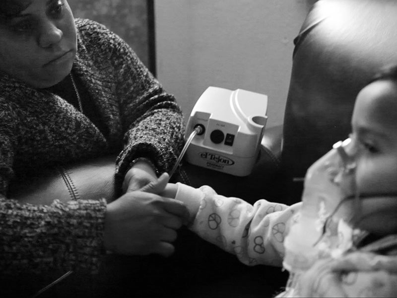 A mother watches over her child during treatment for asthma.