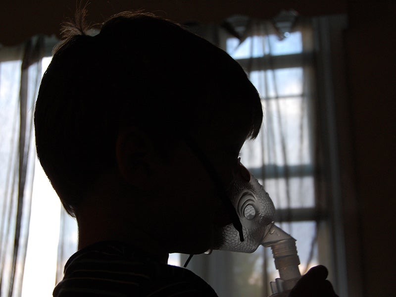 A child receives treatment for asthma. A child receives treatment for asthma.