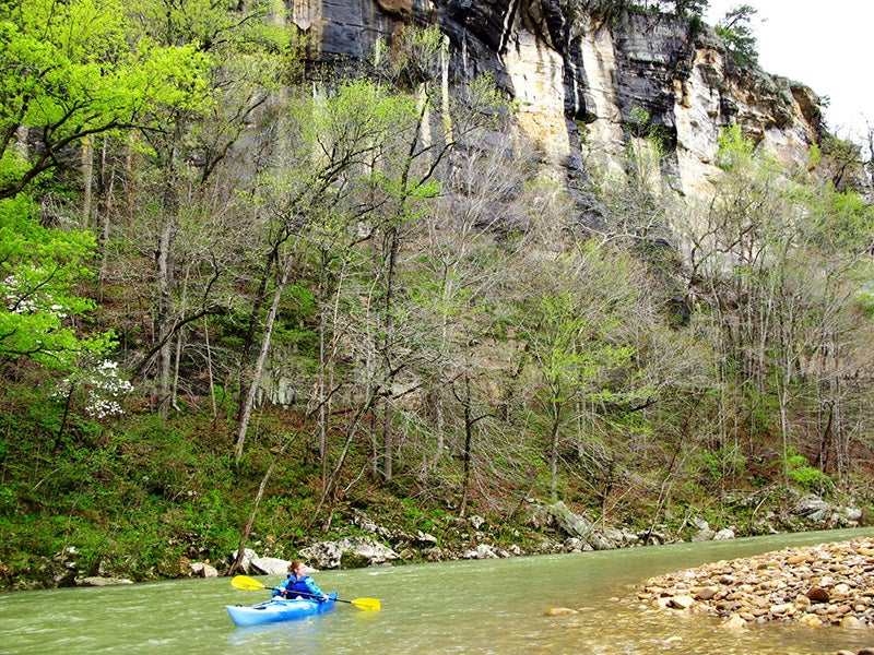 A kayaker paddles down the Buffalo National River. A kayaker paddles down the Buffalo National River.