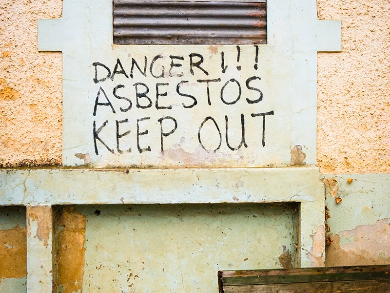 A sign warning of the presence of asbestos. A sign warning of the presence of asbestos.