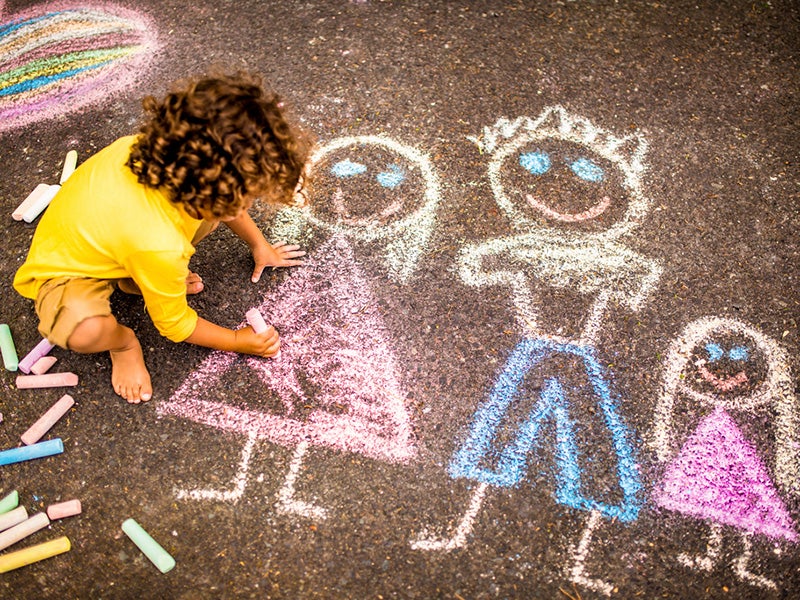 A child draws with chalk.