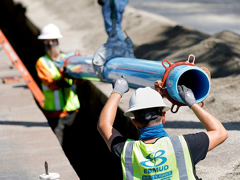 Workers with East Bay Municipal Utility District install new water pipe on April 22, 2021, in Walnut Creek, California. 