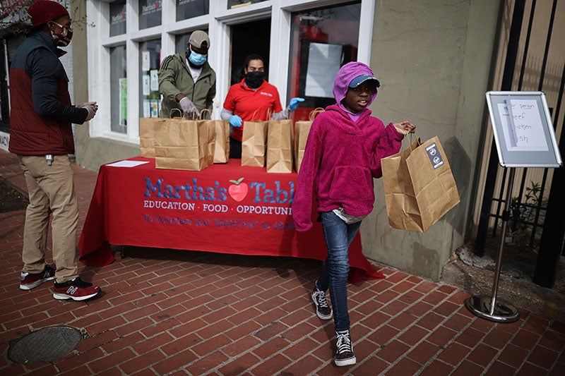 Volunteers at a nonprofit in Washington, D.C., distribute free hot meals during the COVID-19 pandemic. Volunteers at a nonprofit in Washington, D.C., distribute free hot meals during the COVID-19 pandemic.