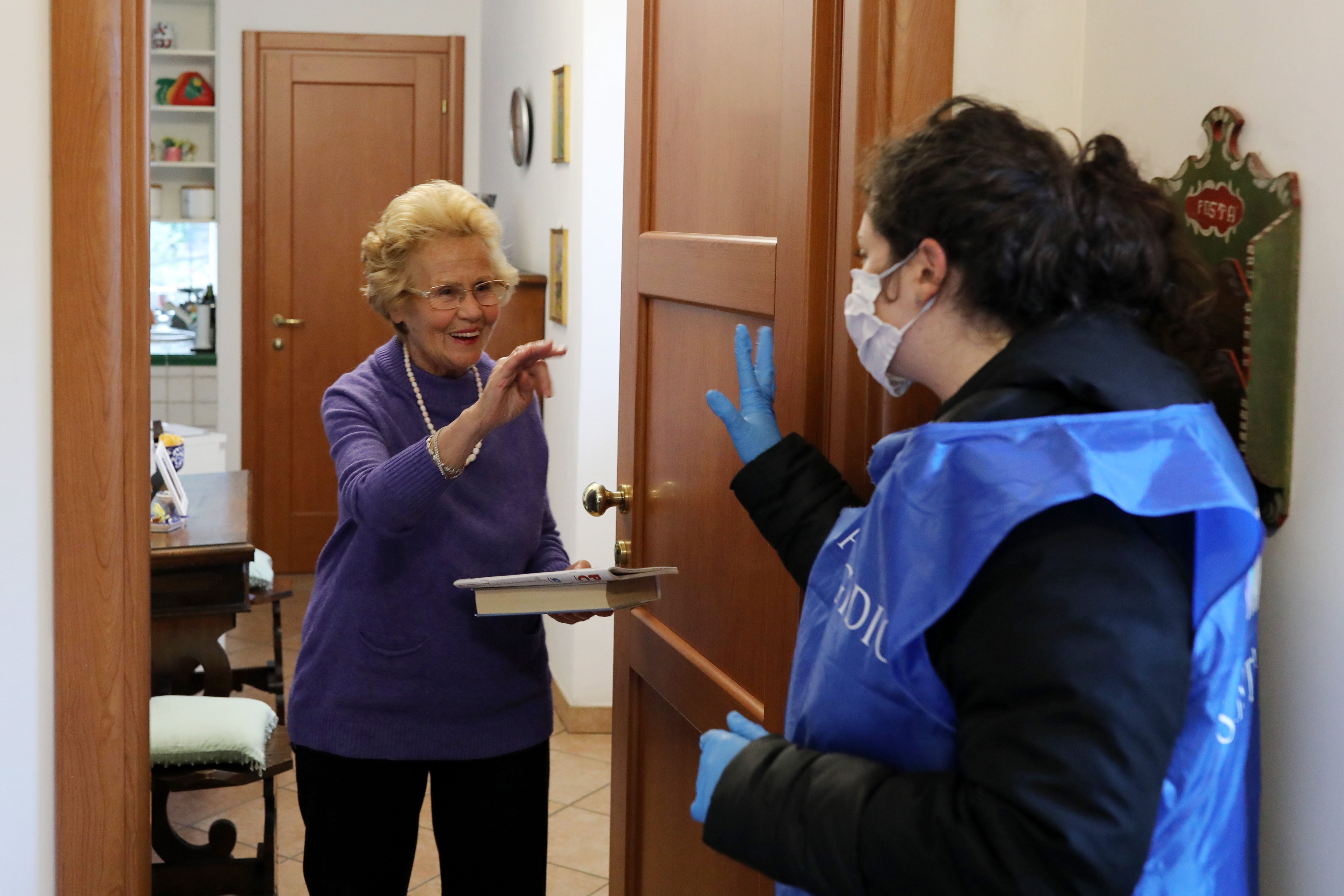 A volunteer speaks to a woman she's providing with home care in Rome during Italy's COVID-19 lockdown.