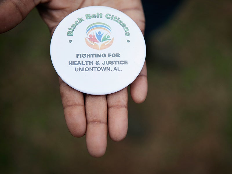 Client Esther Calhoun holds a button from the local community group fighting coal ash pollution in Uniontown, AL. Client Esther Calhoun holds a button from the local community group fighting coal ash pollution in Uniontown, AL.