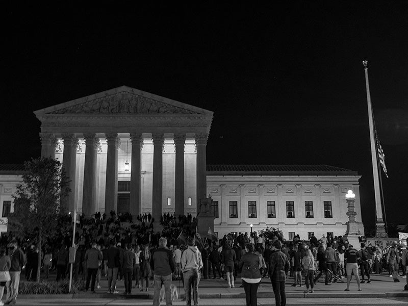 The national flag flies at half staff as people gather to mourn the passing of Supreme Court Justice Ruth Bader Ginsburg at the steps \of the Supreme Court on Sep. 18, 2020, in Washington, D.C.