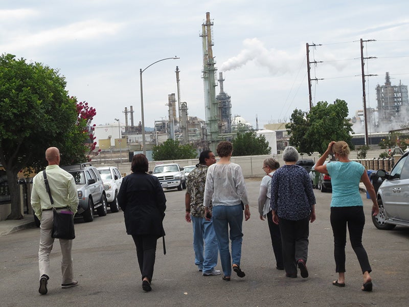 Jesse Marquez of the Coalition for a Safe Environment (third from left) shows EPA staffers and others a Wilmington oil refinery, shortly before the public hearing. Jesse Marquez of the Coalition for a Safe Environment (third from left) shows EPA staffers and others a Wilmington oil refinery, shortly before the public hearing.