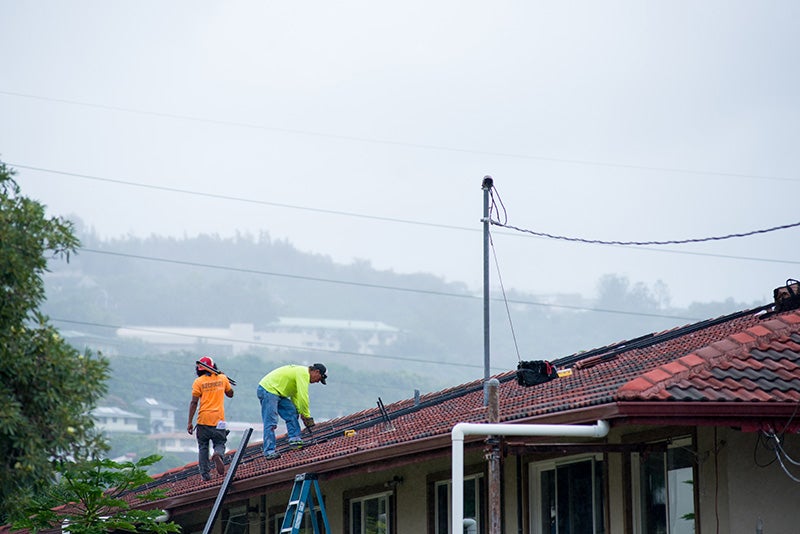 Technicians install solar panels in Honolulu, Hawaii. Technicians install solar panels in Honolulu, Hawaii.