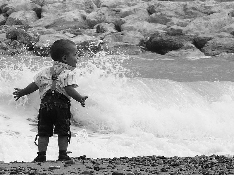 A toddler enjoys a water splash.