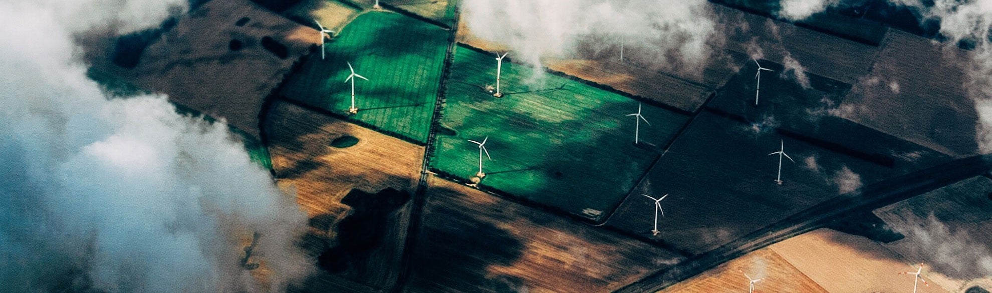 Aerial view through cumulus clouds of a wind turbine farm in an agricultural field. Aerial view through cumulus clouds of a wind turbine farm in an agricultural field.