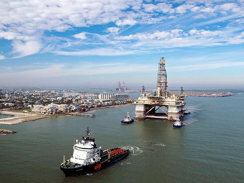 Tugboats tow the semi-submersible drilling platform Noble Danny Adkins through the Port Aransas Channel into the Gulf of Mexico in 2020 in Port Aransas, Texas.