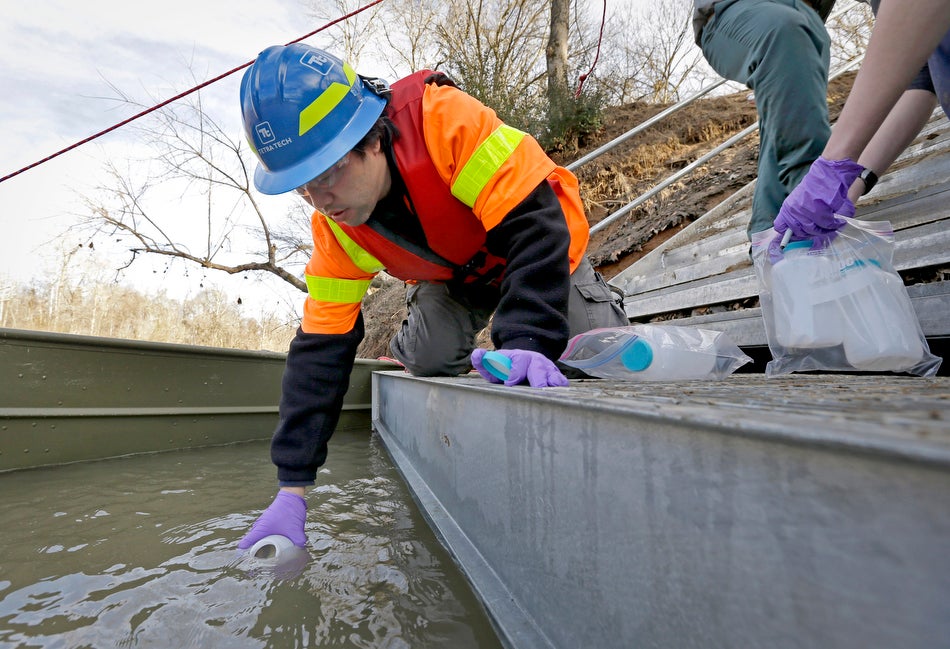 An EPA contractor collects a water sample from the site of a coal ash spill on the Dan River in North Carolina.
(Gerry Broome / AP)