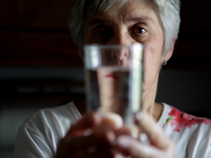 A woman examines her drinking water.