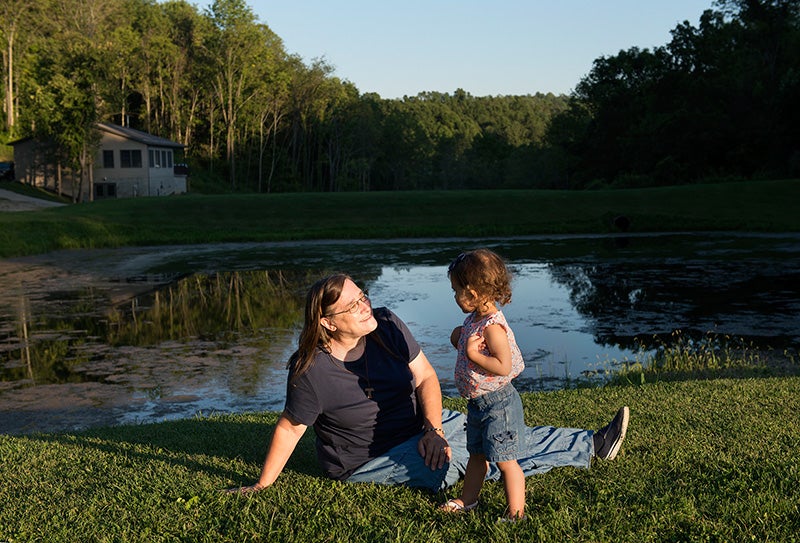 Schumacher, with her granddaughter. The pond behind them filled with debris from a pipeline project during a rainstorm.