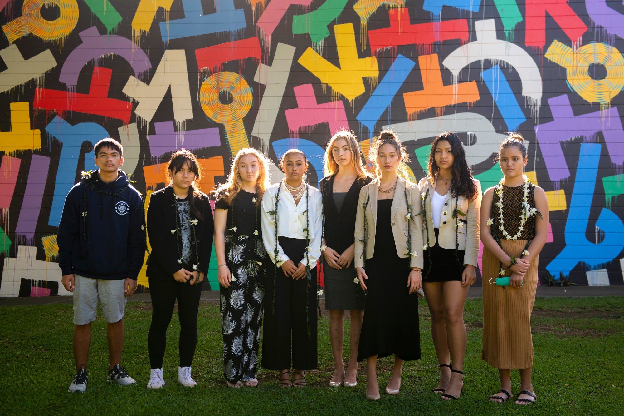 Teens in front of a colorful mural.