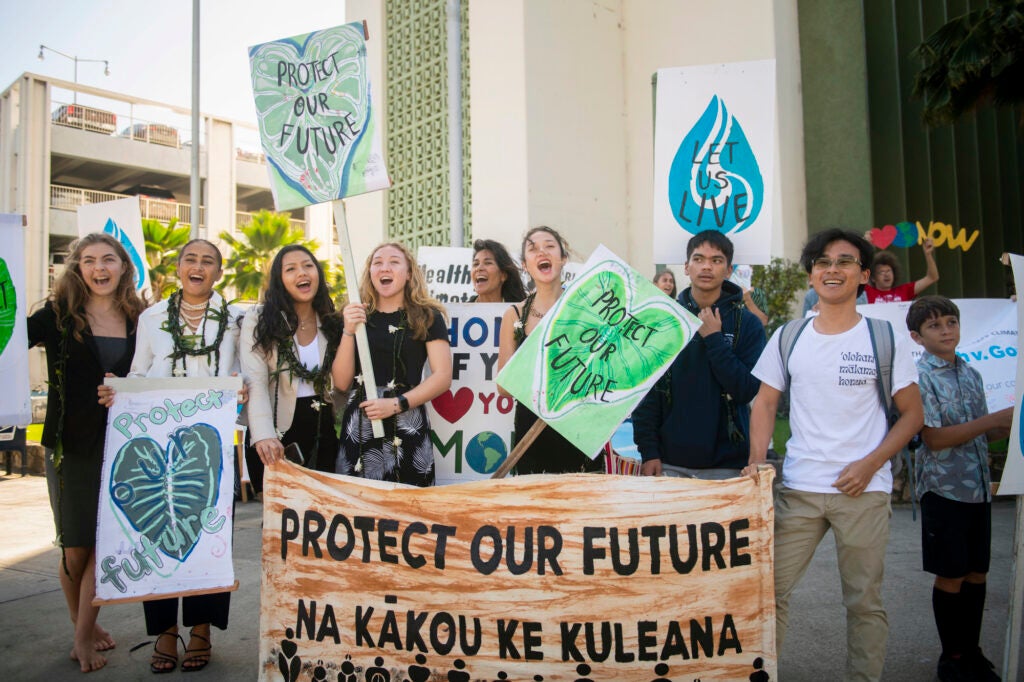Youth plaintiffs and supporters hold up signs after the Navahine vs the Hawai'i Department of Transportation court hearing in Honolulu, Hawaii on January 26th 2023. (Elyse Butler for Earthjustice)