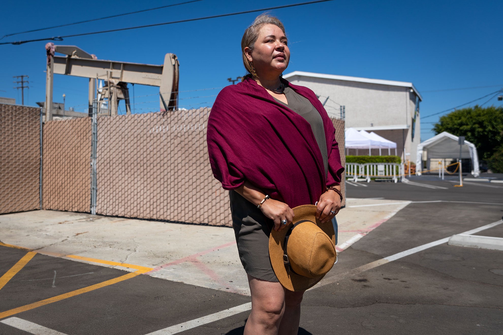 Magali Sanchez-Hall, in the parking lot of Harbor Christian Center in Wilmington, California, where an oil derrick sits.