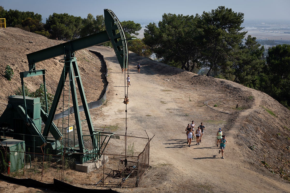 An active oil derrick towers over a busy neighborhood trail in Signal Hill's Panorama Promenade.