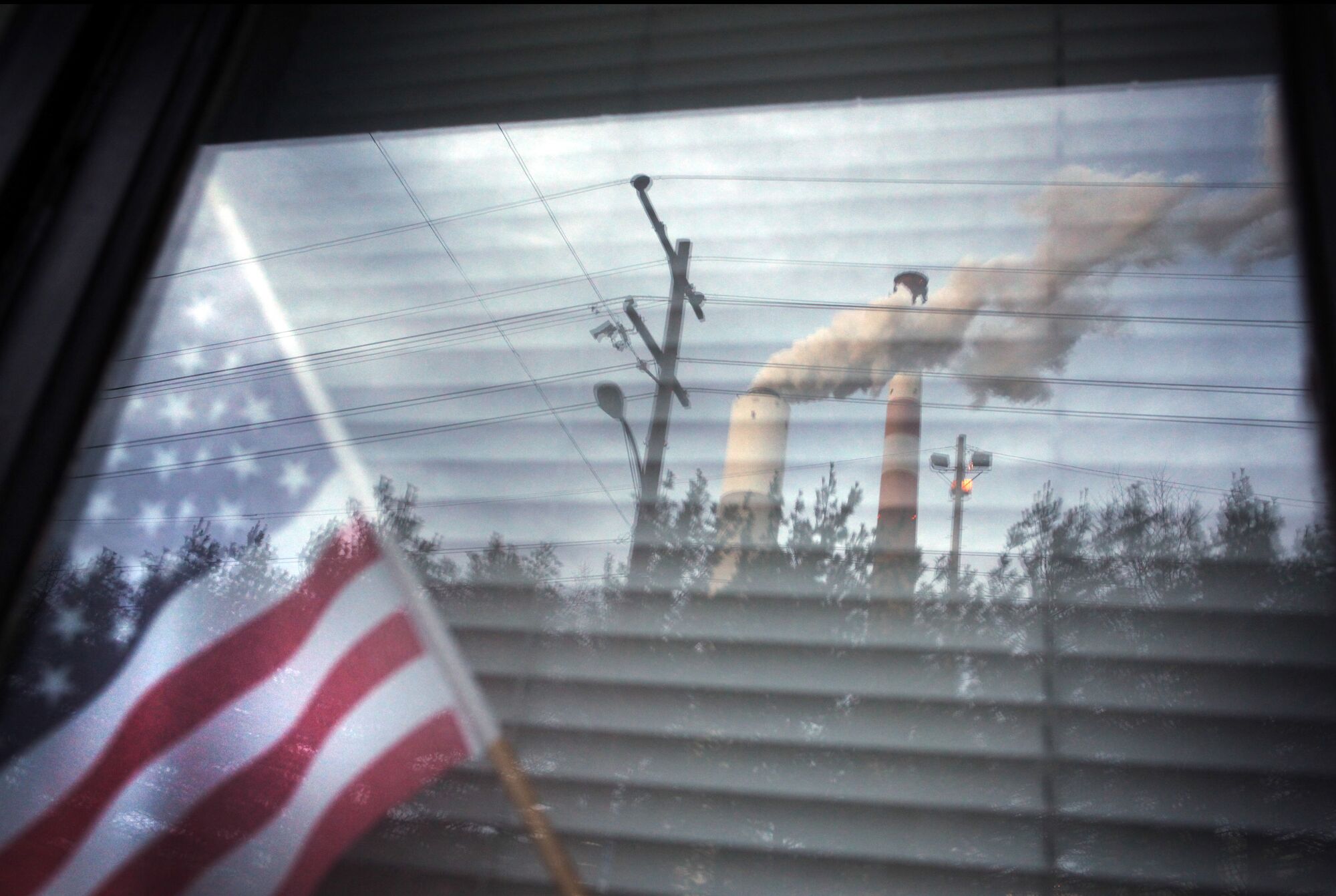 The Cheswick coal-fired power plant in Pennsylvania, reflected in a window of a home in Springdale, is among the hundreds of power plants likely covered by the Mercury & Air Toxics Standards.
