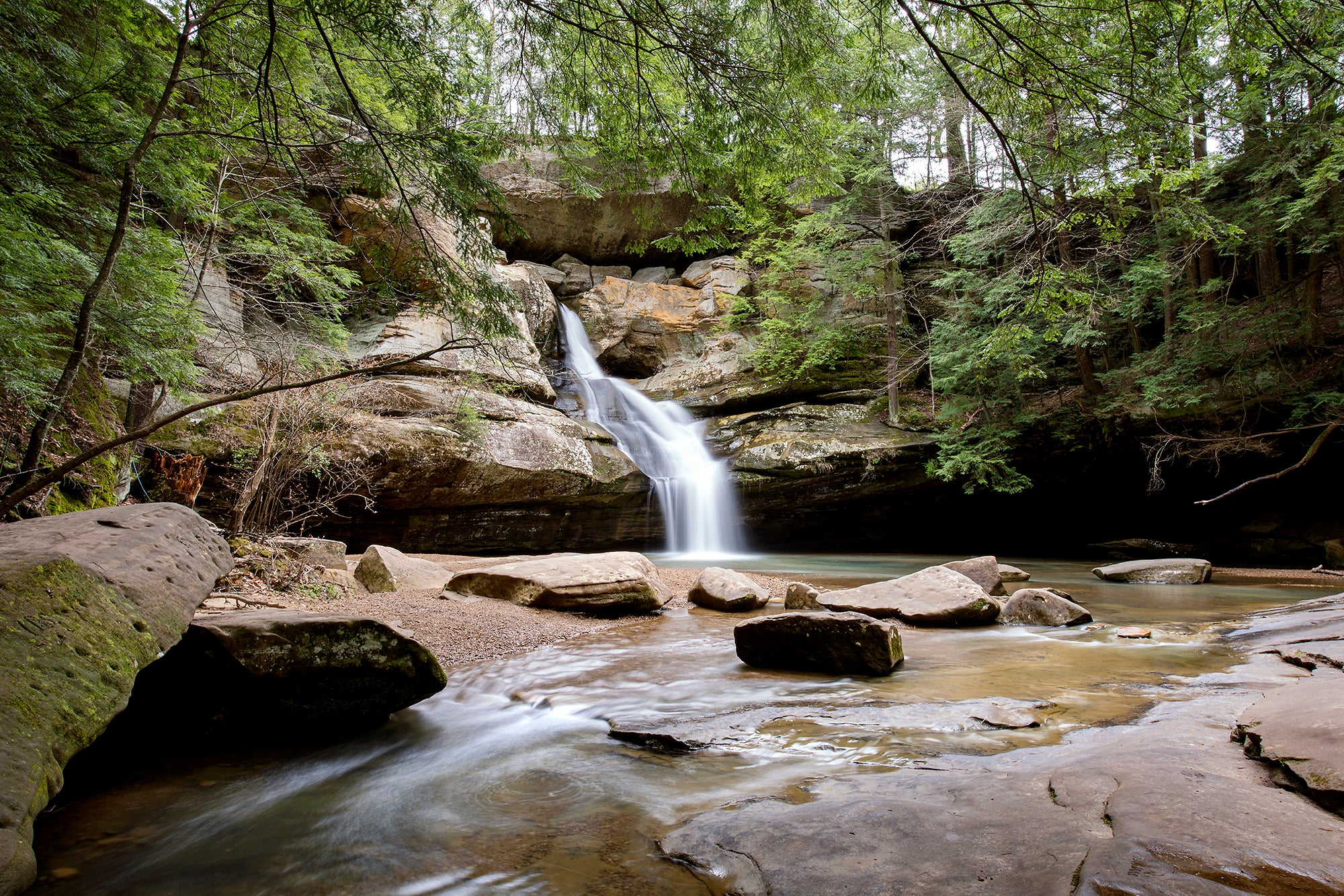 Green trees, waterfall, peaceful scene with no people.