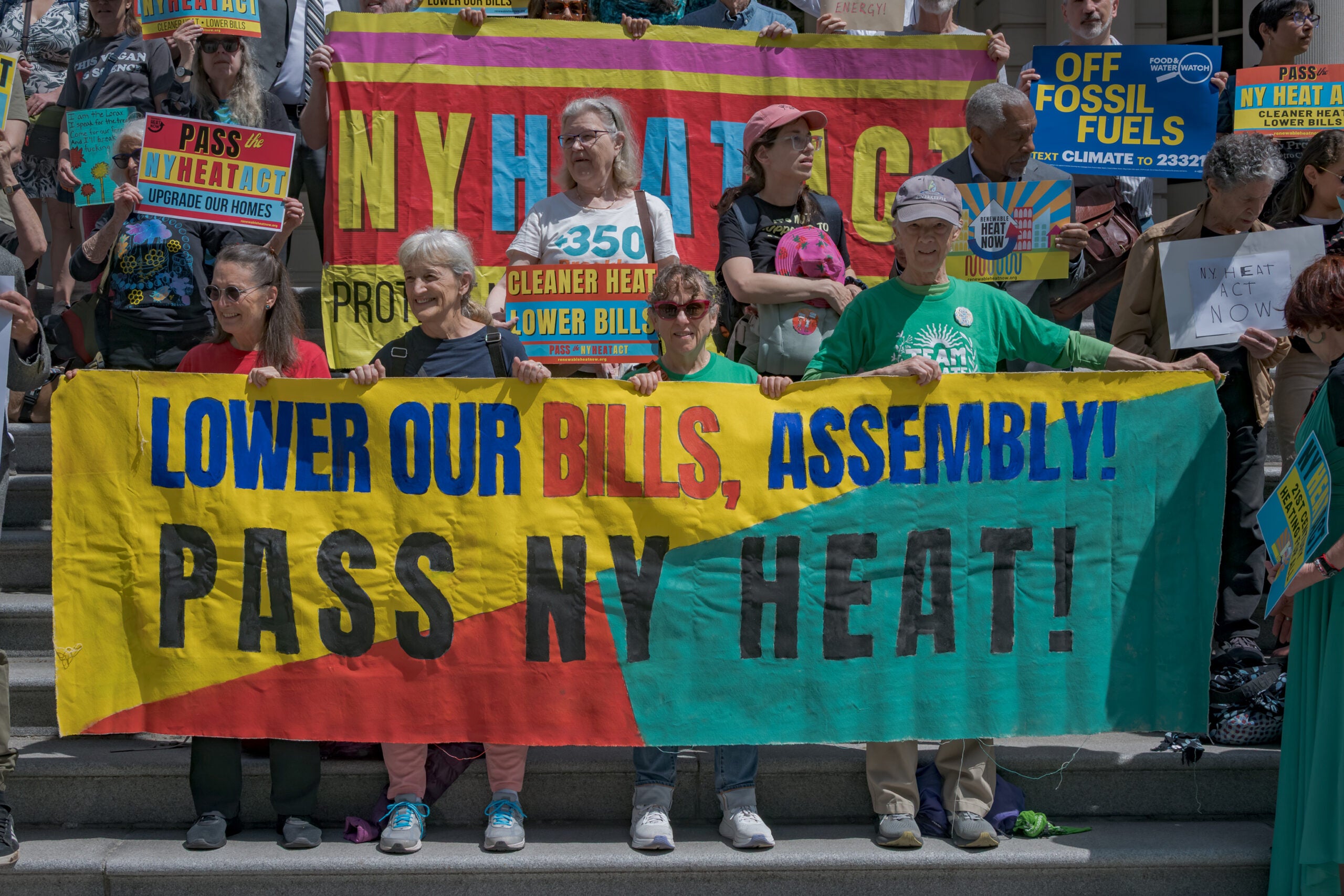 Participants seen holding a banner at the rally. Over 100 Over 100 New Yorkers joined environmental organizations on Earth Day at the steps of City Hall to rally for the NY HEAT Act, a major climate and affordability bill that would cut emissions and saving low and moderate income New Yorkers an average of $136 per month. (Erik McGregor / LightRocket via Getty Images)
