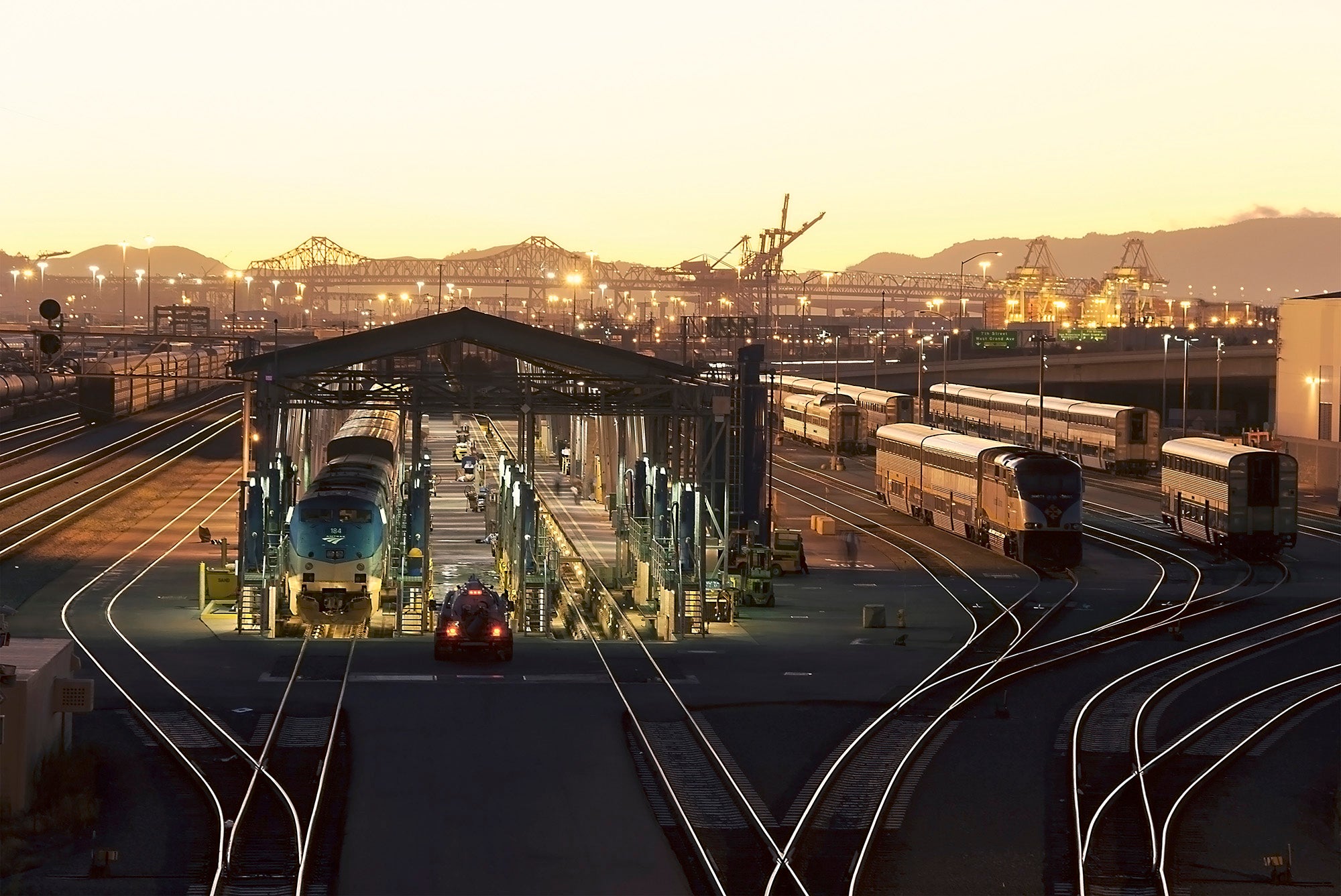 Photo taken at sunset with the Port of Oakland behind the trains.