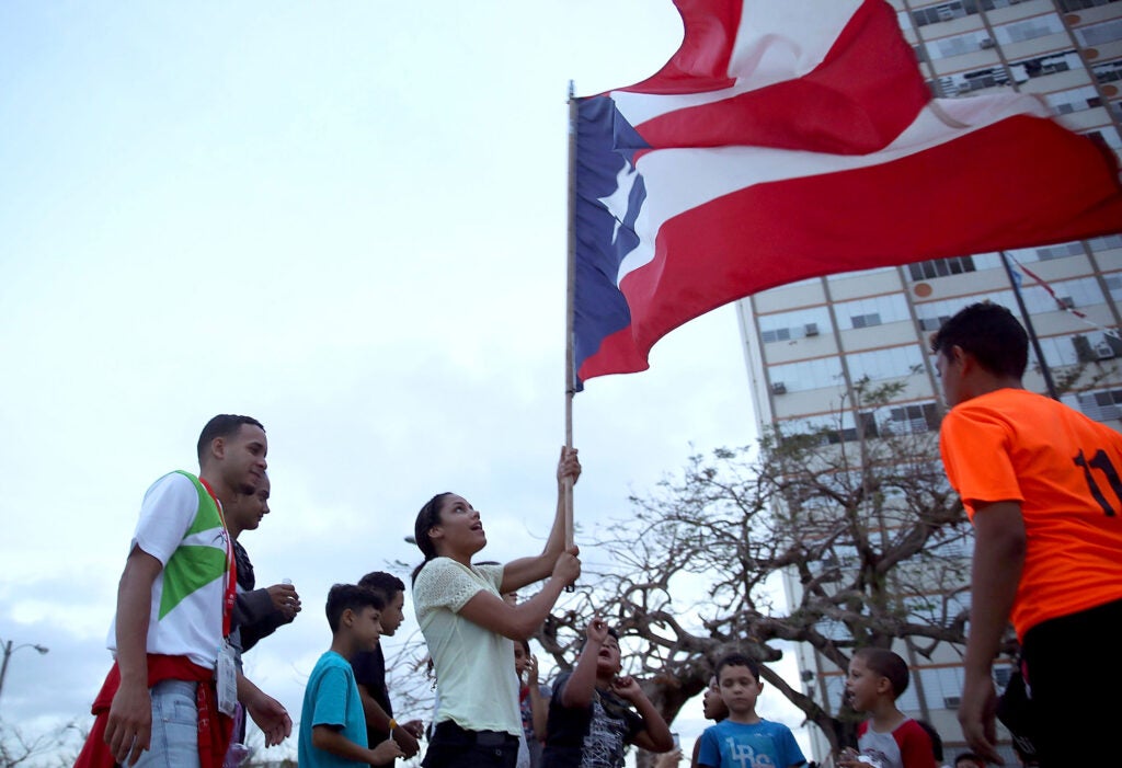 A Puerto Rican flag is waved outside the Torres de Francia Complex, as people deal with the aftermath of Hurricane Maria on Oct. 1, 2017, in San Juan, Puerto Rico.