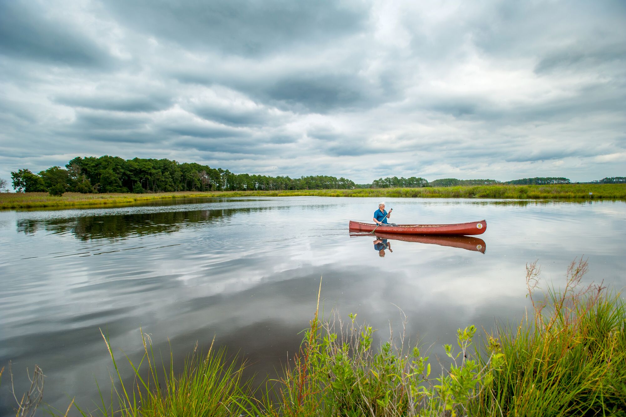 A river guide in a canoe under cloudy skies, near Marion Station, Maryland.