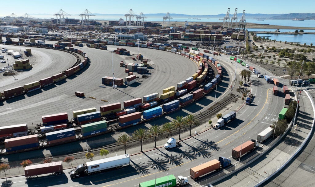 Trucks and train cars carrying shipping containers line up at the Port of Oakland in California. (Justin Sullivan / Getty Images)