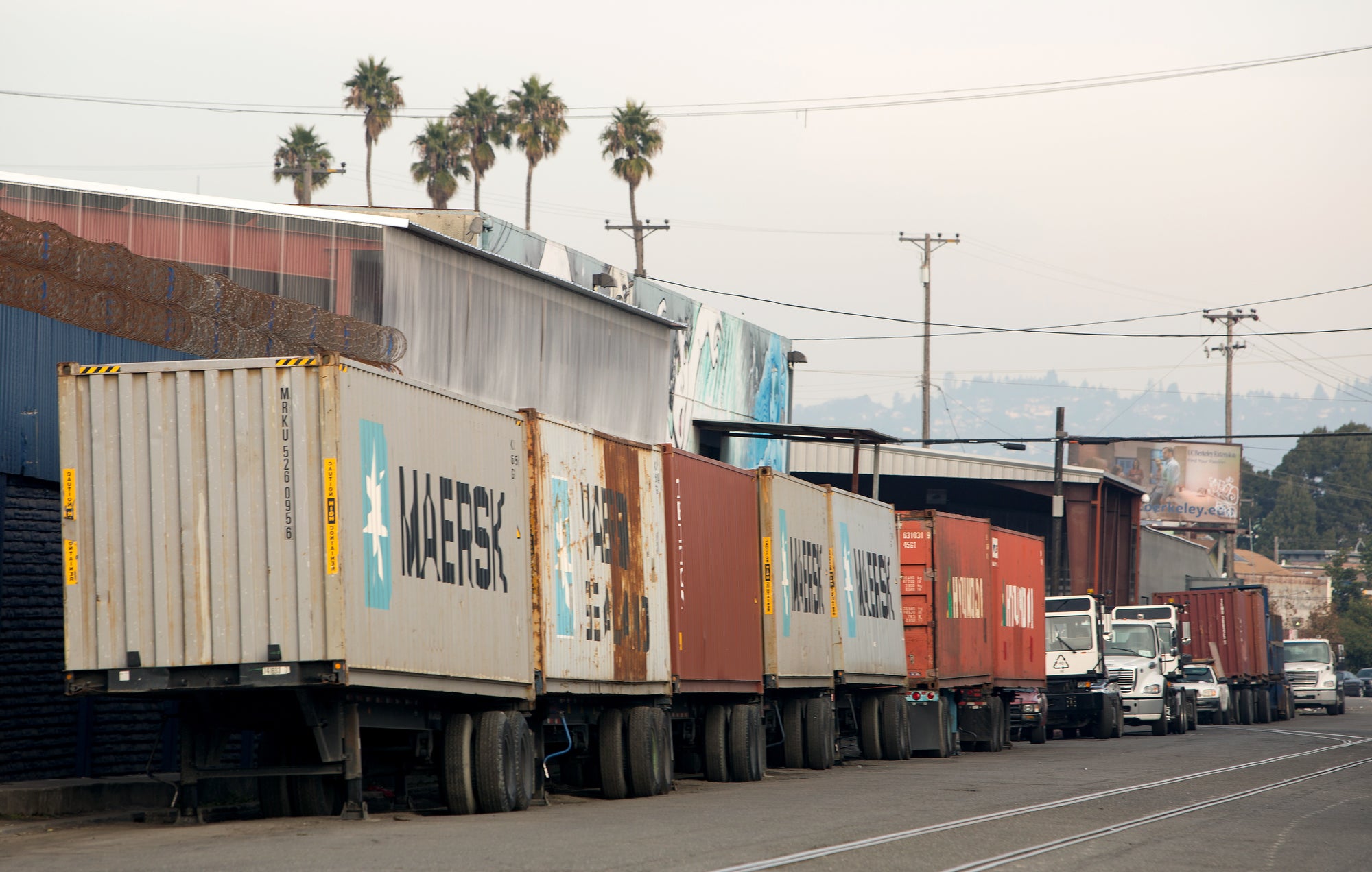 Shipping containers on trailers lined up on a West Oakland street.