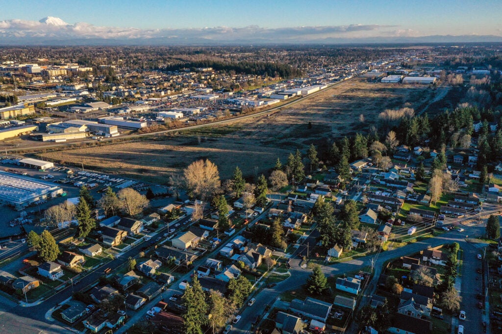 Aerial photo of field surrounded by homes and businesses.