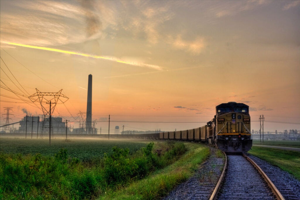 In the early hours, a coal train empties its load. Traveling from Gillette, Wyoming, to New Madrid, Missouri, a one-week journey delivering 15,000 tons of coal, enough to keep this massive plant operating for one day.