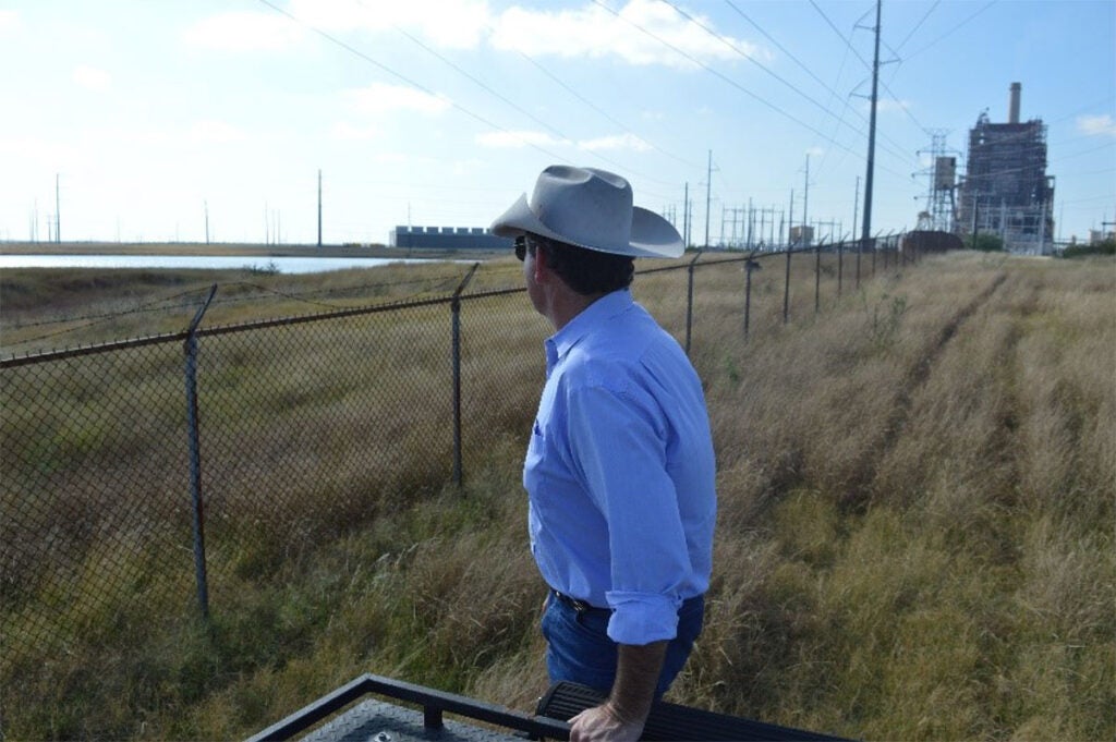 A South Texas rancher looks out over his family’s land that has been contaminated by pollutants from the San Miguel Electric Plant, in the background.