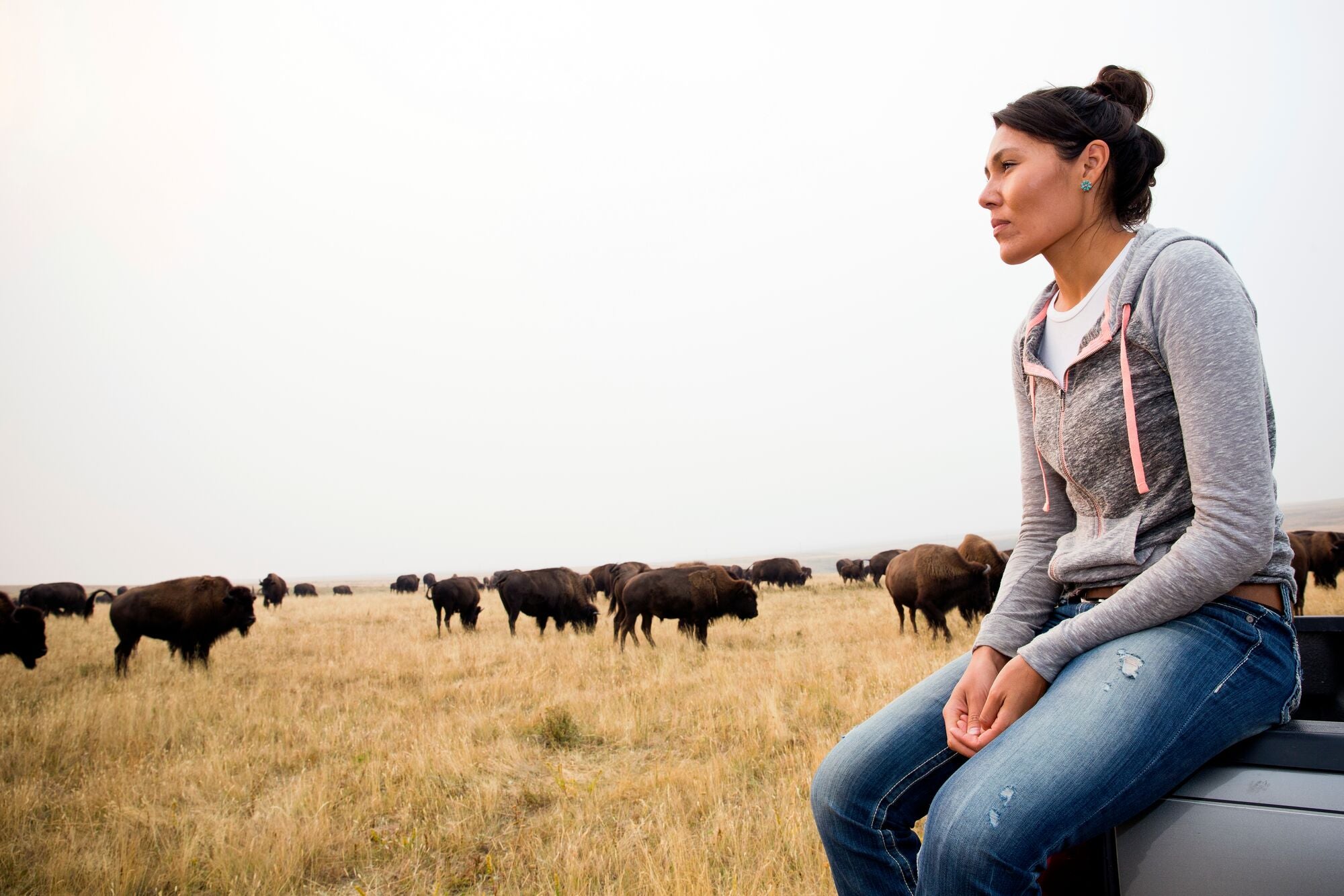 Edmo, who was previously the Bison Project Coordinator for the Tribe, watches over bison at the Blackfeet Nation's Bison Reserve in Browning, Montana.