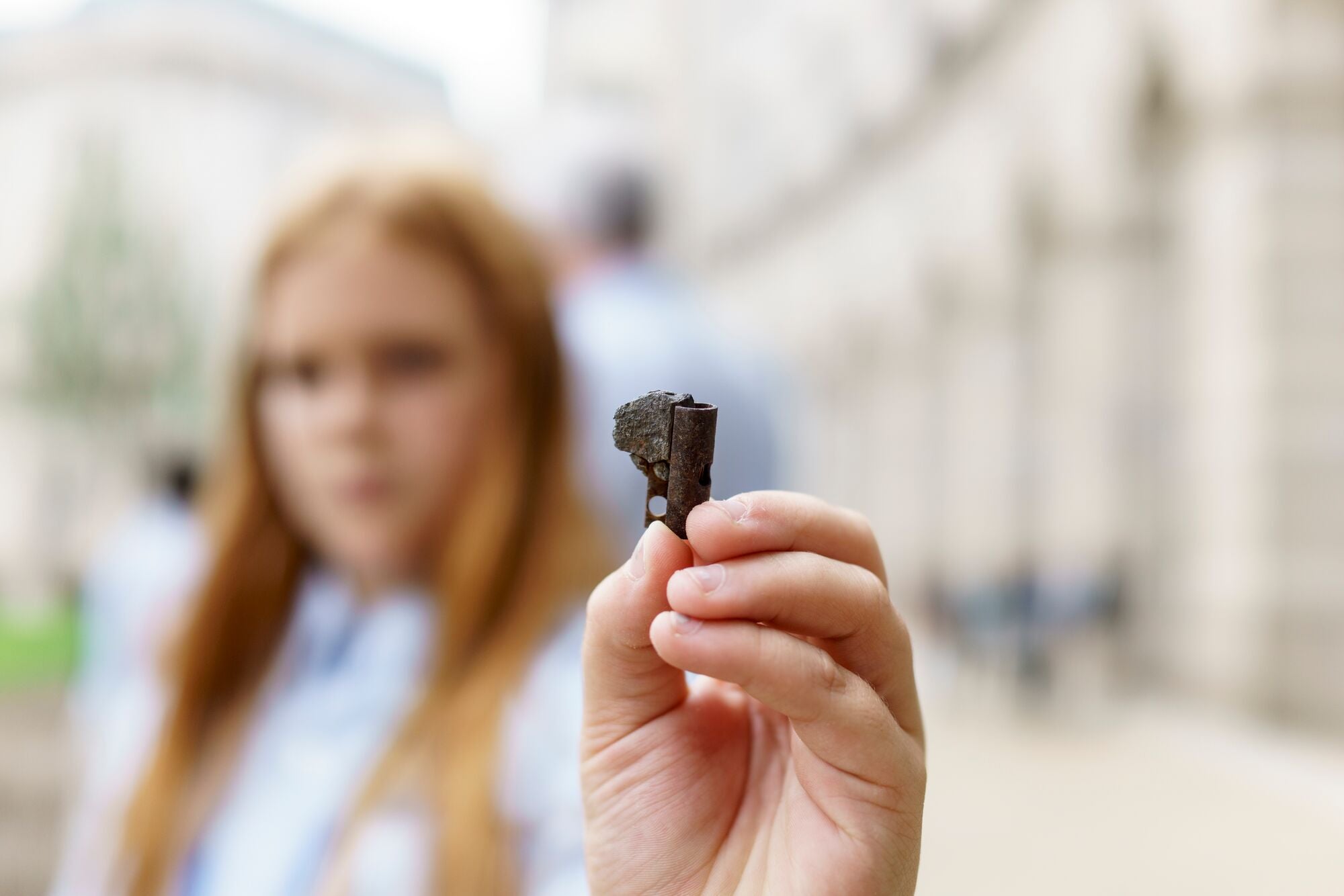 A youth scientist who asked the U.S. EPA to ban lead wheel weights holds up a fragmented part of a lead wheel weight found a block from the U.S. EPA building along Constitution Ave., in Washington D.C.