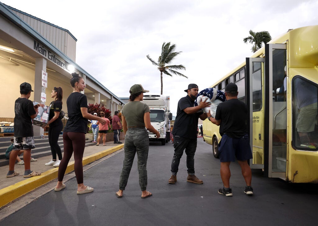 Volunteers with King's Cathedral Maui unload donations of blankets and supplies on August 10, 2023 in Kahului, Hawaiʻi. Dozens of people were killed and thousands displaced after a wind-driven wildfire devastated the town of Lahaina on Tuesday. (Justin Sullivan / Getty Images)