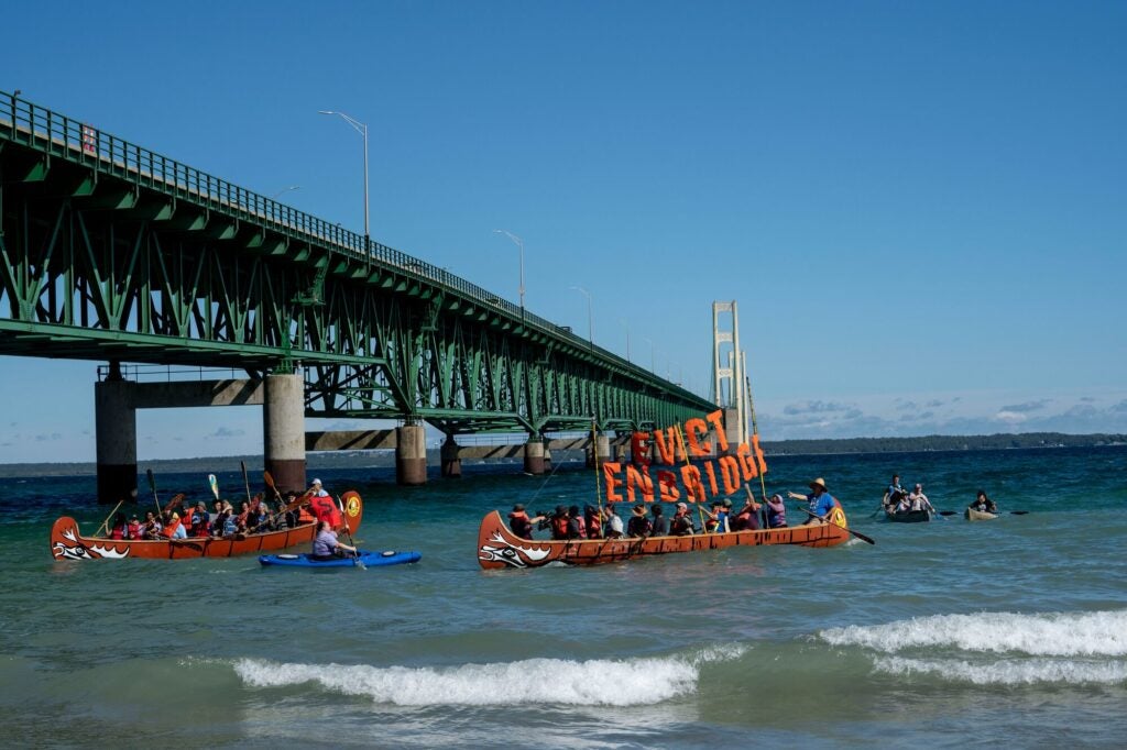Protestors paddle next to the Mackinac Bridge at the Pipe Out Paddle Up Flotilla Against the Line 5 pipeline in Mackinaw City, Michigan. (Sarah Rice for Earthjustice)