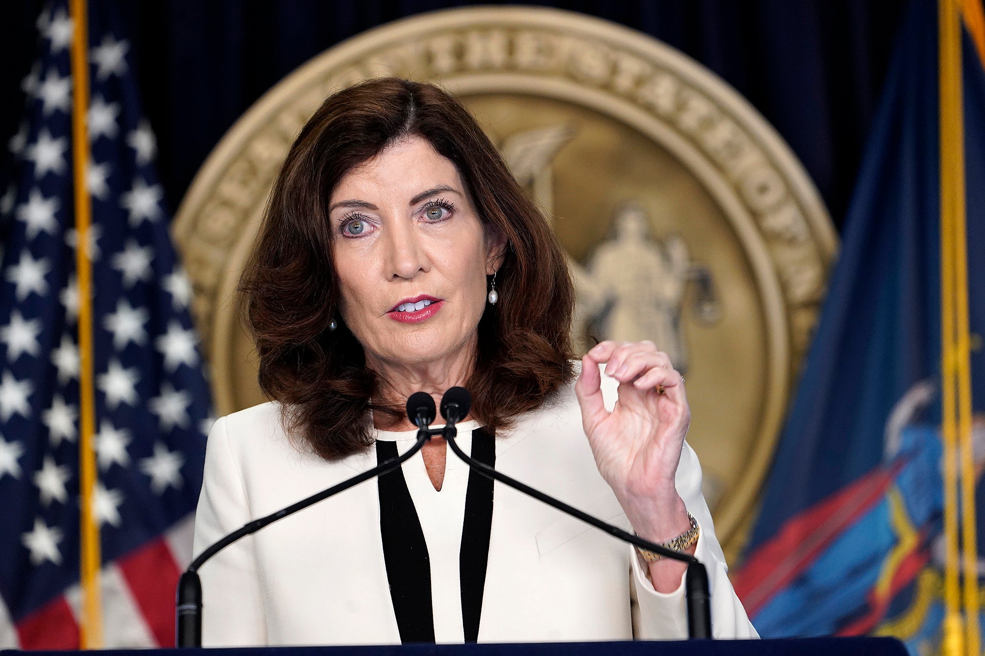 New York Gov. Kathy Hochul speaks at a podium with the seal of New York behind her.