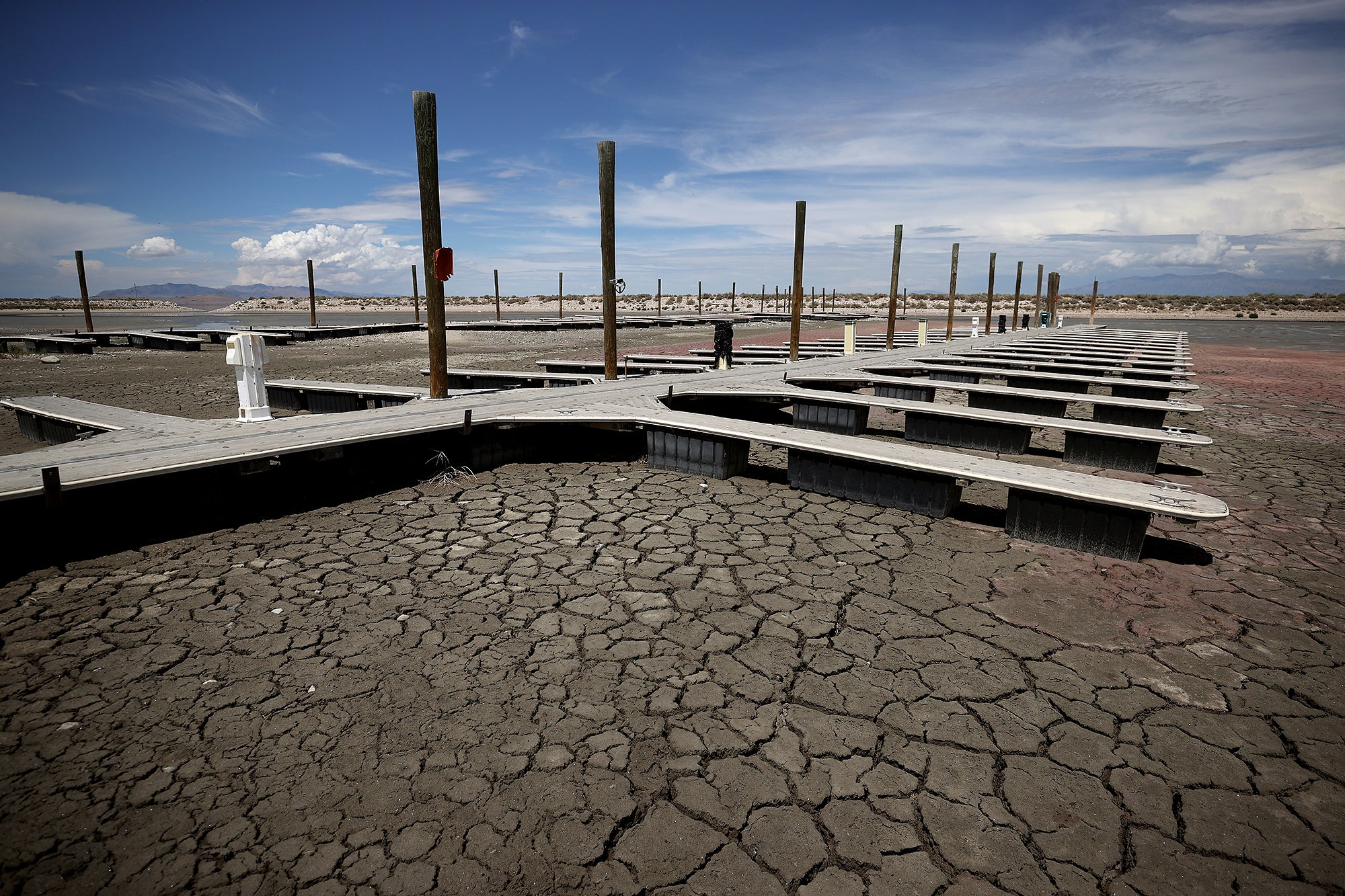 A boat dock sits on dry, cracked ground with no water in sight.