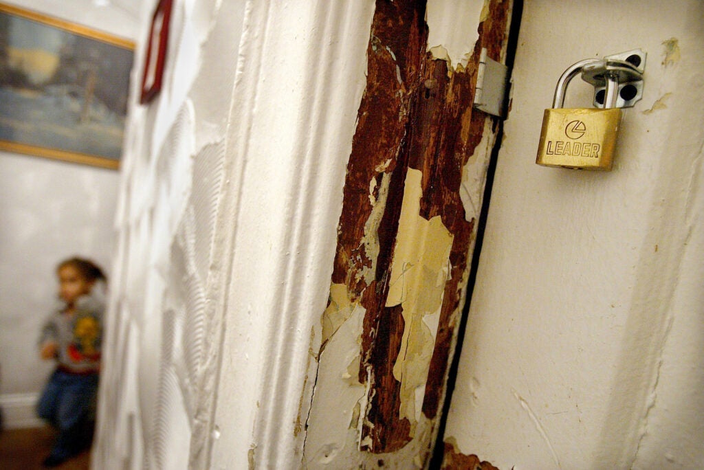 Children that have high levels of lead in their blood stand next to a peeling lead paint wall in their apartment in New York City. Children ingest lead paint and lead paint dust, resulting in lead poisoning, which causes irreversible brain and central nervous system damage. While lead paint was banned in housing construction in New York in 1960, buildings built before 1960 still have high amounts of lead which landlords, especially in impoverished neighborhoods, are reluctant to remove.  (Spencer Platt / Getty Images)