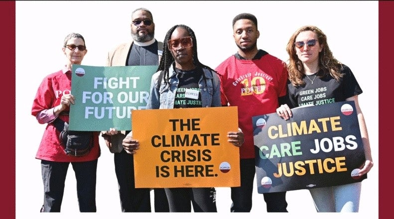 Members of POWER Interfaith stand holding signs that say "Fight for Our Future," "The Climate Crisis is Here," and "Climate, Care, Jobs, Justice."