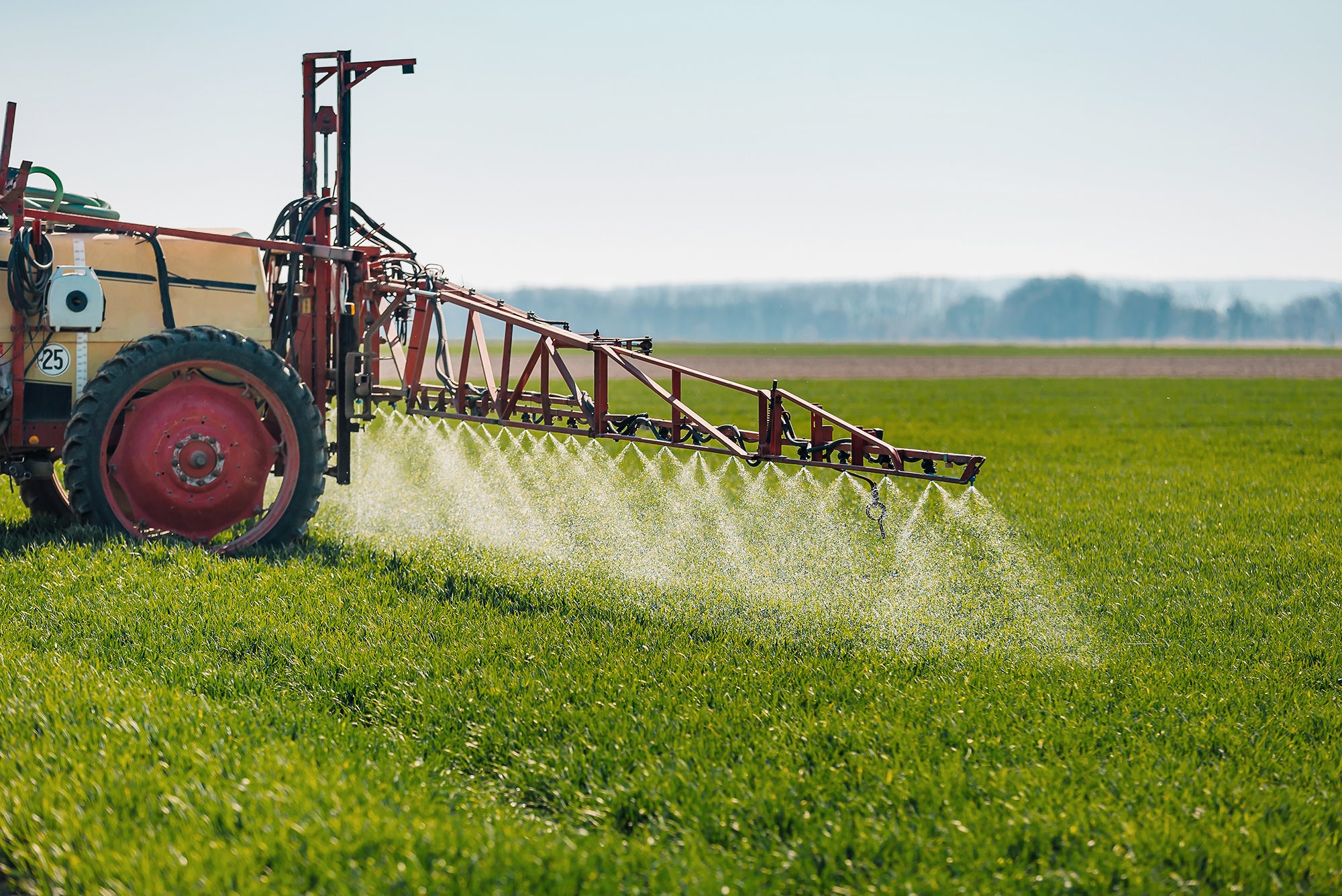 Chemicals being sprayed on a field of crops