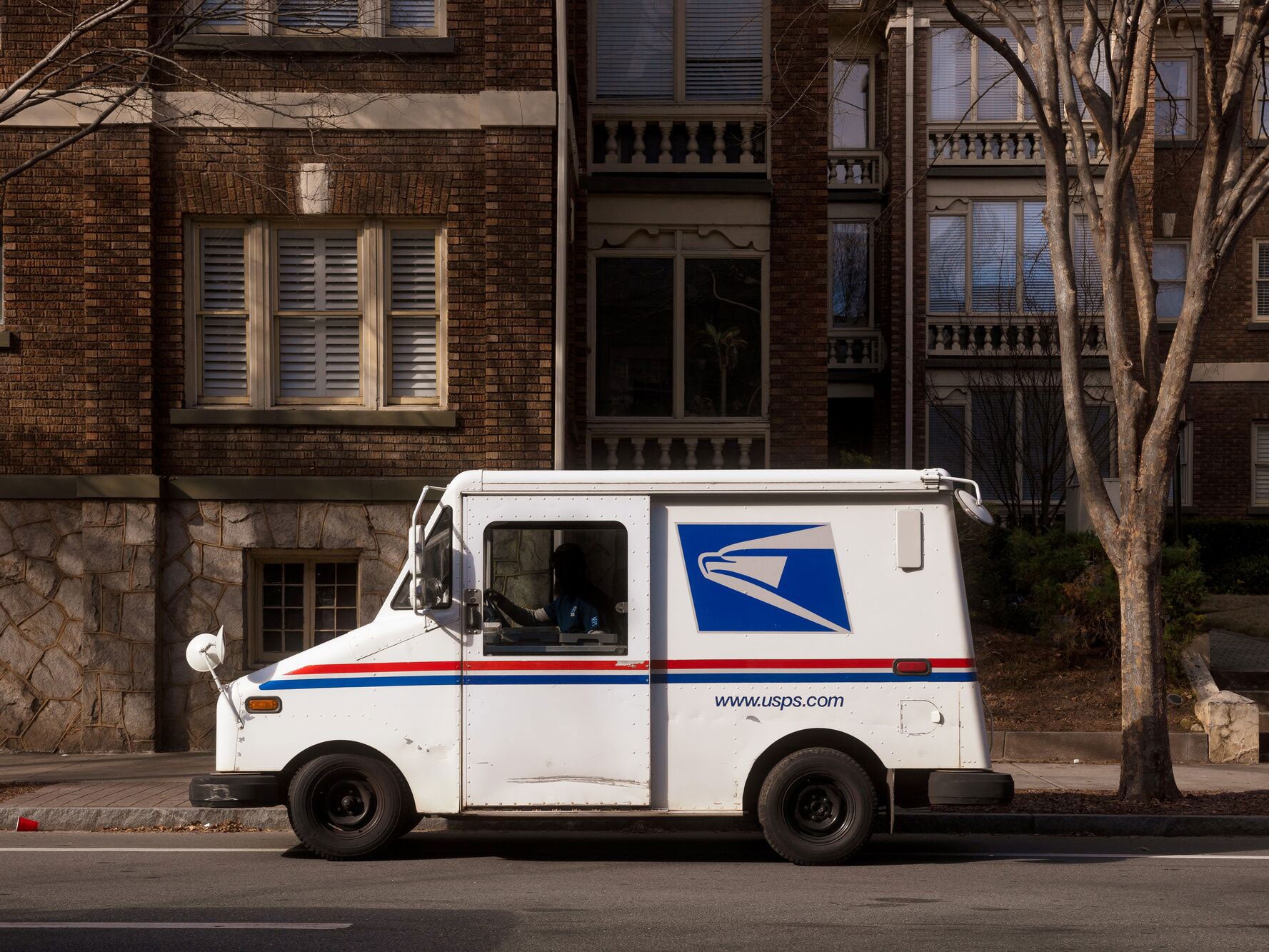 A USPS truck makes its rounds in midtown Atlanta. (Eric Saulsberry / Shutterstock)